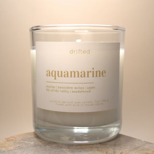 Candle labeled 'aquamarine' with a beige label on a neutral background