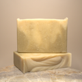 Two bars of soap on a stone surface with a neutral background