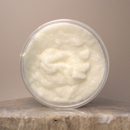 Jar of white body scrub on a stone surface with a beige background