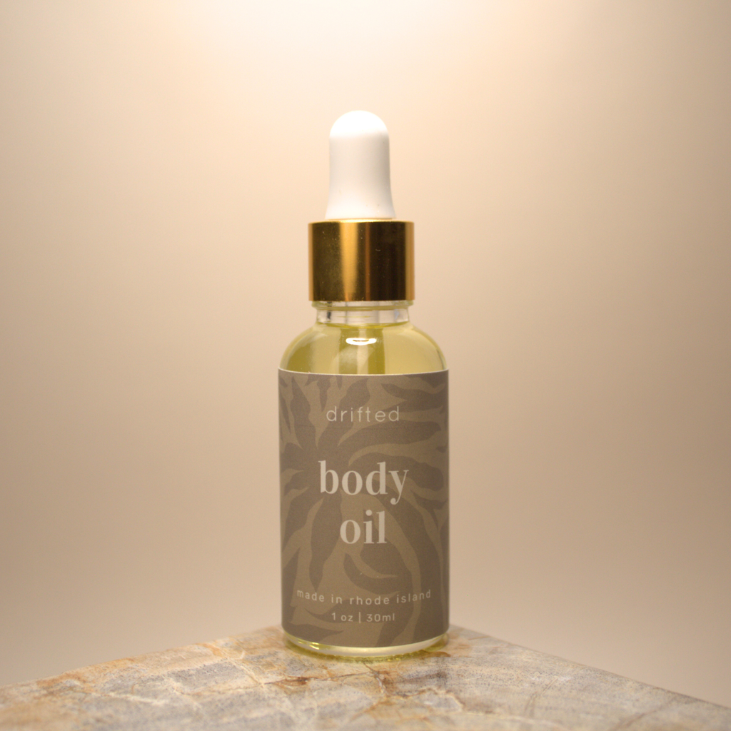 Bottle of body oil with dropper on a beige background
