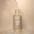 Bottle of body oil with dropper on a neutral background