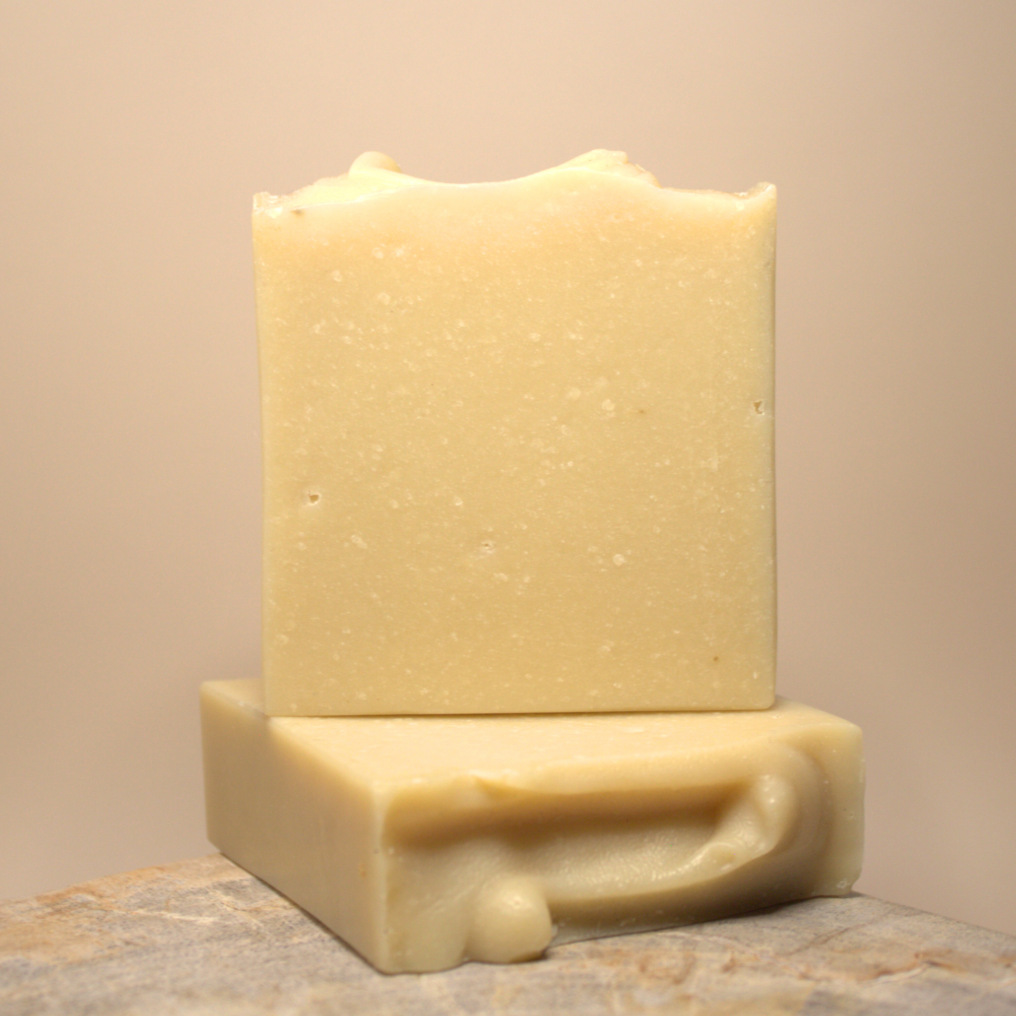 Two bars of soap stacked on a neutral background