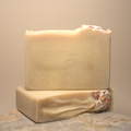 Two bars of soap on a textured surface with a neutral background